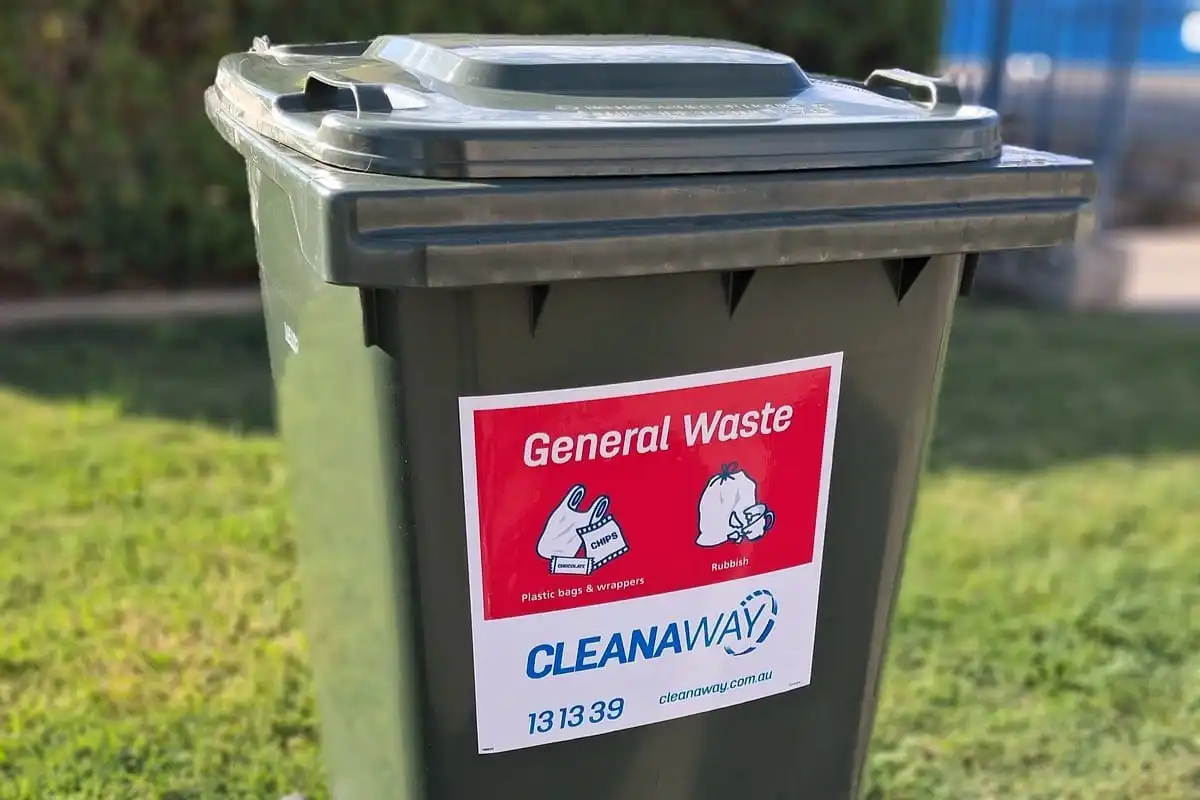 Green-lid general waste bin with a red sticker highlighting acceptable waste